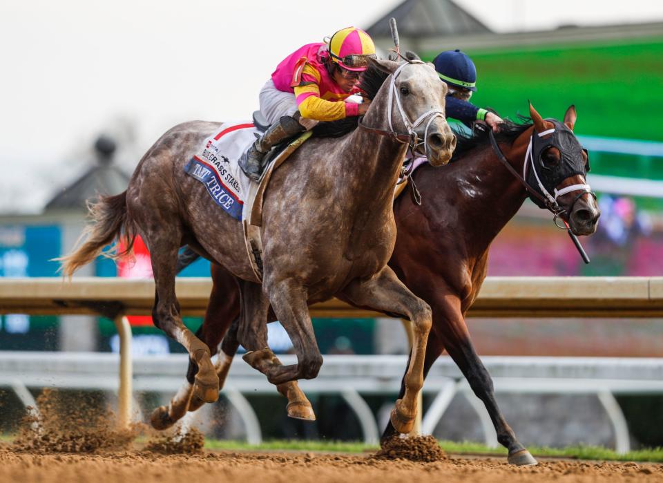 Jockey Luis Saez aboard Tapit Trice rides past Tyler Gaffalione on Verifying to claim the 2023 Toyota Blue Grass Stakes April 8 at Keeneland. April 8, 2023