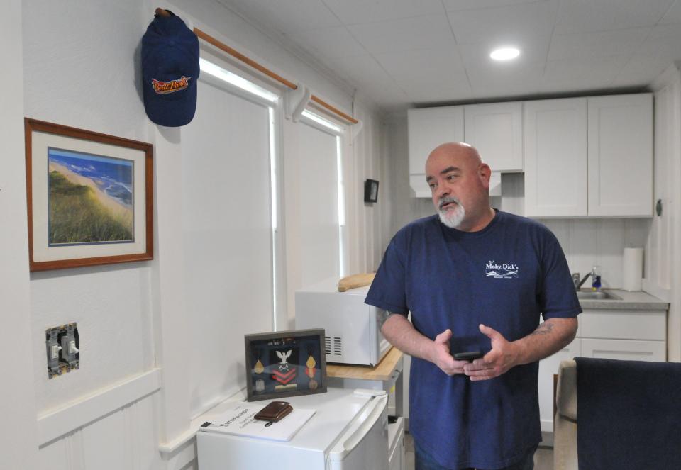 Liberty Lodge resident Howard Goldman, a U.S. Navy veteran, stands in his unit in Sandwich where he's lived for close to two years. His unit includes a kitchen area and room for a bed. The former motel has fallen into disrepair, putting veteran housing and safety at risk, Goldman said.