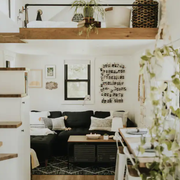 interior of the tiny house showing the couch and a small set of stairs up to the bed