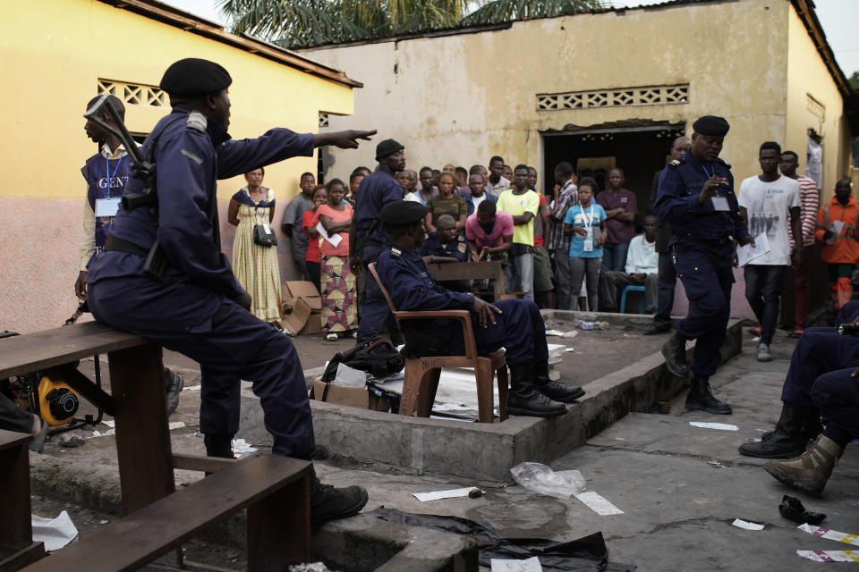 Police officers secure the Les Anges primary school in Kinshasa, Congo. Sunday Dec. 30, 2018. The voting process was delayed when angry voters burned six voting machines and ballots mid-day, angered by the fact that the registrations lists had not arrived. Replacement machines had to be brought in, and voting started at nightfall, 12 hours late. Forty million voters are registered for a presidential race plagued by years of delay and persistent rumors of lack of preparation. (AP Photo/Jerome Delay)