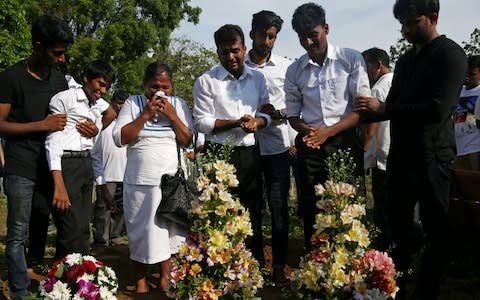 Relatives collapsed in tears at the mass burial of victims, two days after a string of suicide bomb attacks on churches and luxury hotels across the island.  - Credit: &nbsp;ATHIT PERAWONGMETHA/REUTERS