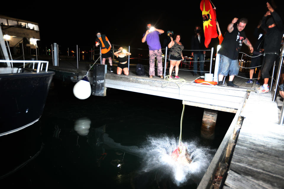 <p>The head of the statue of Egerton Ryerson is brought to Toronto Harbour. Protesters threw the head into the harbour to cleanse it and then relieved it to preserve it for Land Back. (Steve Russell/Toronto Star via Getty Images)</p> 