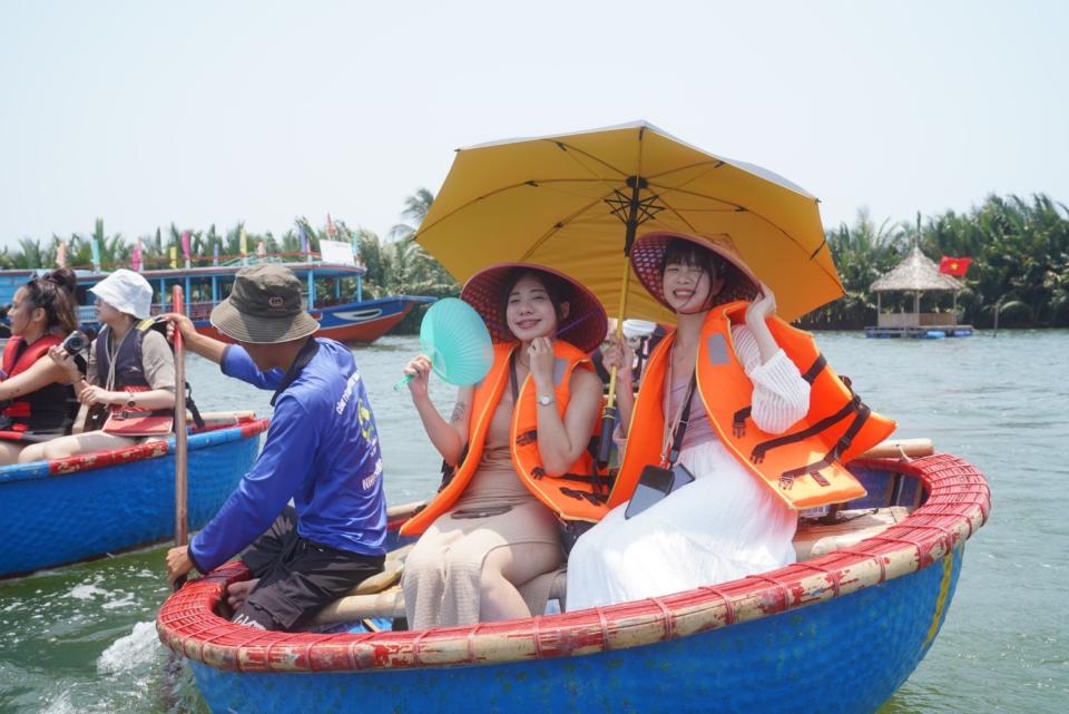 船伕貼心提供遮陽傘和斗笠，還會繞幾句中文和遊客聊天。