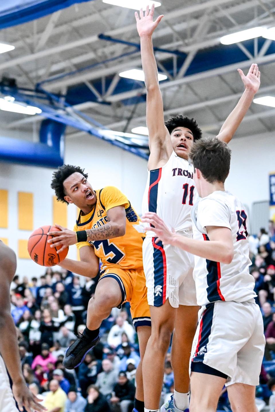 Battle Creek Central's Kierre Young, left, shoots as East Lansing's Cameron Hutson defends during the third quarter on Wednesday, March 15, 2023, DeWitt High School.