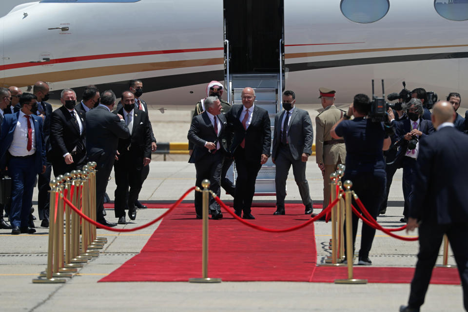 Iraqi President Barham Salih, center, welcomes Jordan's King Abdullah II, upon his arrival at Baghdad Airport, Iraq, Sunday, June 27, 2021. (AP Photo/Khalid Mohammed)