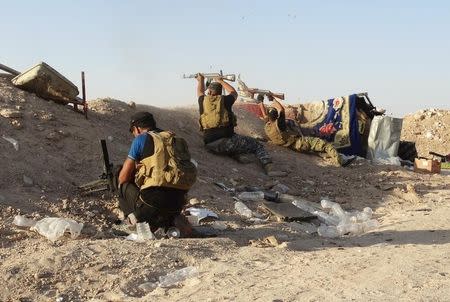 Iraqi security forces fire their weapons during clashes with Islamic State militants on the outskirts of Ramadi June 15, 2015. REUTERS/Stringer