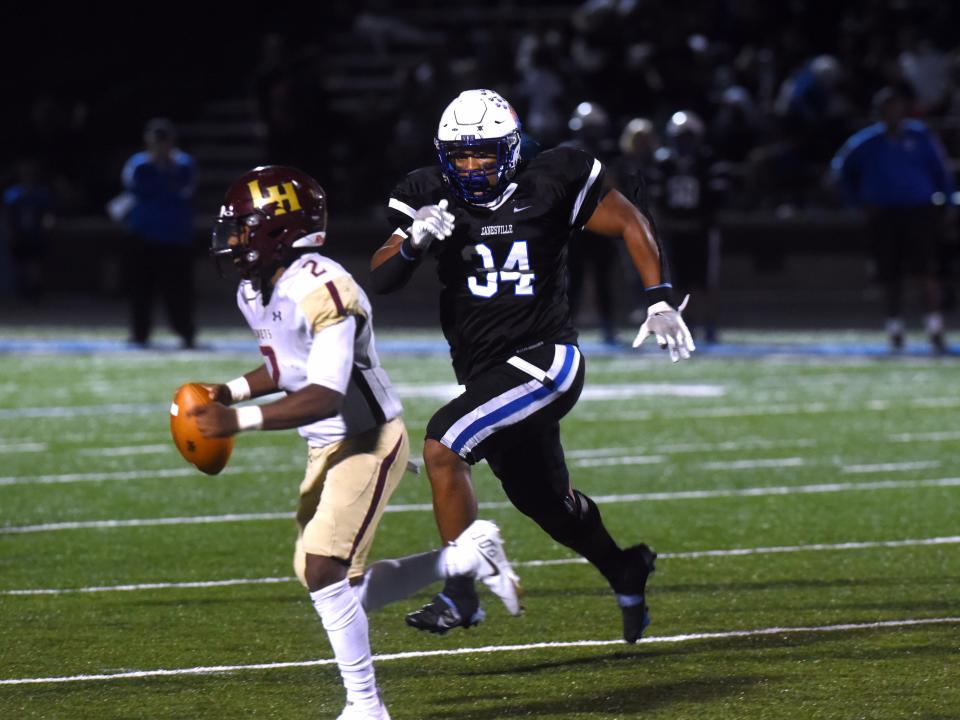 Zanesville defensive end Kanye Evans chases Licking Heights quarterback Deuce Caldwell in a game earlier this season. Evans made the Division III first team on the defensive line.