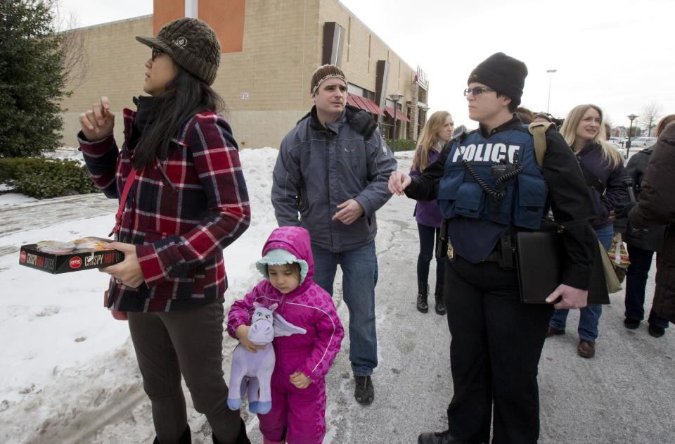 La policía del condado de Howard escolta a compradores mientras son evacuados del Centro Comercial en Columbia, Maryland, un suburbio de Baltimore y Washington, después de un tiroteo el sábado 25 de enero de 2014 en Howard County, Maryland. ( Foto AP//Manuel Balce Ceneta)