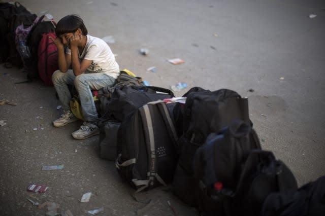 A young boy sits on luggage