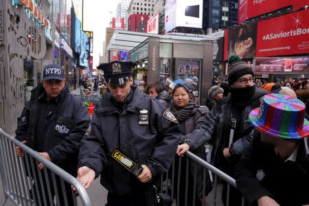 New York Police Department officers set up barriers to prevent entry to a pen where revelers will wait for the beginning of New Year's Eve festivities in the Times Square area of New York December 31, 2015. REUTERS/Lucas Jackson