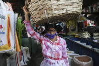 Una vendedora de fruta, con una mascarilla sobre la boca, camina por un mercado popular en Managua, Nicaragua, el 7 de abril de 2020. Los restaurantes están vacíos, hay poco tráfico en las calles y los bañistas escasean pese a ser Semana Santa aunque el gobierno pidió a los nicaragüenses que sigan con su vida pese a la pandemia de coronavirus. (AP Foto/Alfredo Zúñiga)