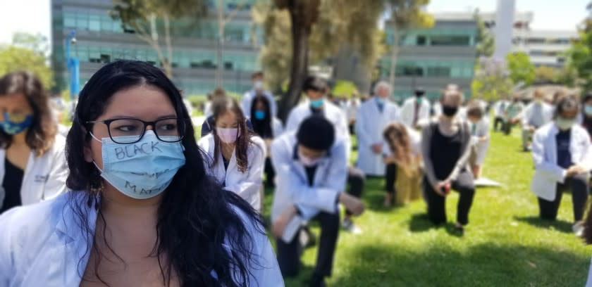 UC San Diego medical students kneel during an anti-racism rally at noon Monday on the La Jolla campus.