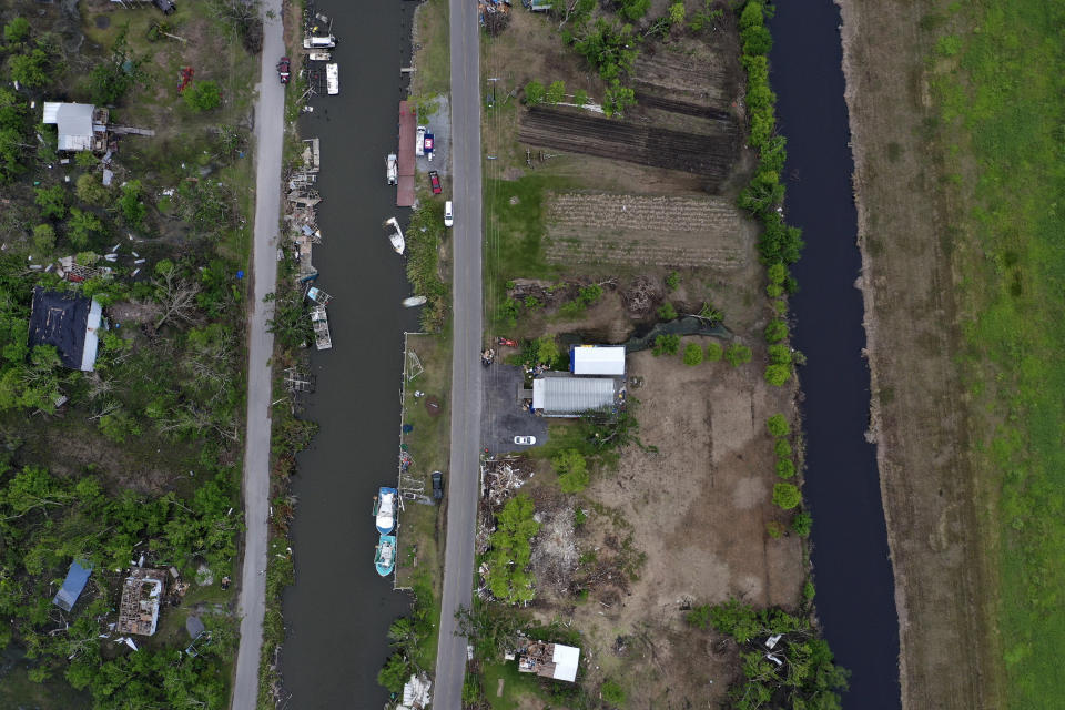 Fallen trees, sunken boats and mangled homes sit alongside the Pointe-au-Chien Bayou on Wednesday, Sept. 30, 2021, a month after Hurricane Ida made landfall in southern Louisiana. (AP Photo/Jessie Wardarski)