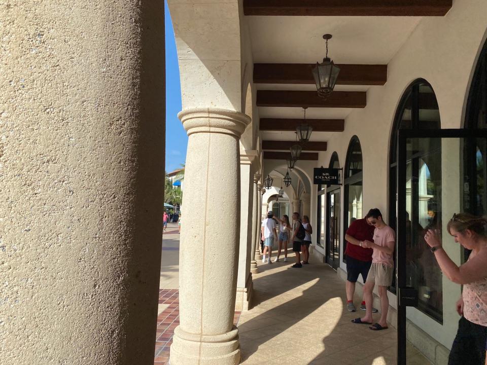 People gather in the shade at Disney Springs in July 2022.