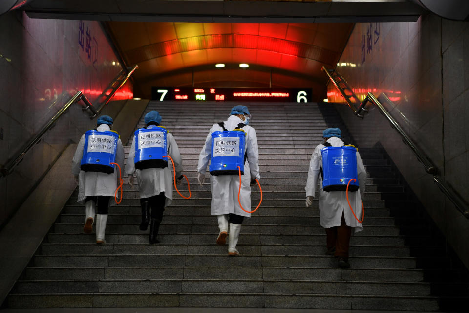 Workers with sanitizing equipment walk up a flight of stairs as they disinfect a railway station while the country is hit by an outbreak of the new coronavirus, in Kunming, Yunnan province, China February 4, 2020. Picture taken February 4, 2020. cnsphoto via REUTERS   ATTENTION EDITORS - THIS IMAGE WAS PROVIDED BY A THIRD PARTY. CHINA OUT.     TPX IMAGES OF THE DAY