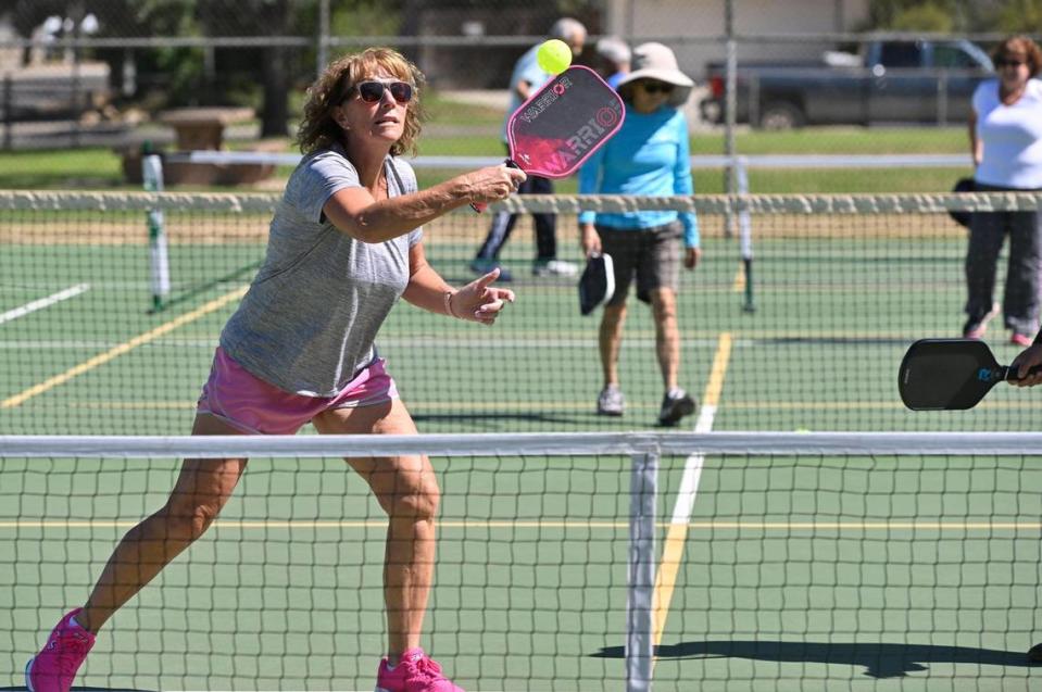 Laurie Werner returns the ball in a doubles pickleball game played on a tennis court at Rotary East Park Wednesday morning, June 21, 2023 in Fresno. Although surrounding towns have dedicated pickleball courts, Fresno and Clovis area fans of the game must share the use of tennis courts with added pickleball lines.