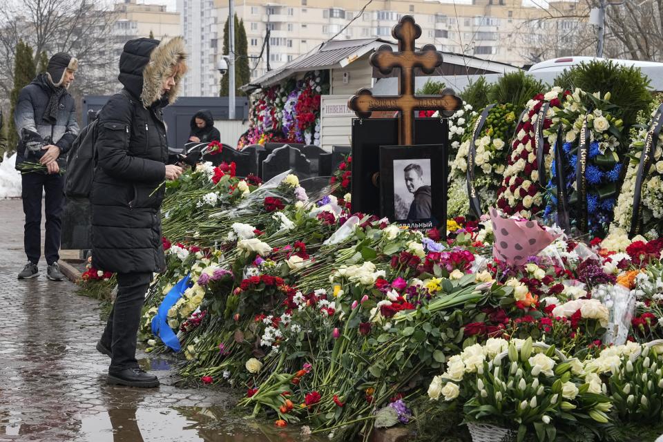 A woman lays flowers at the grave of Alexei Navalny a day after his funeral at the Borisovskoye Cemetery, in Moscow, Russia, on Saturday, March 2, 2024. Navalny, who was President Vladimir Putin's fiercest foe, was buried after a funeral that drew thousands of mourners amid a heavy police presence. (AP Photo)