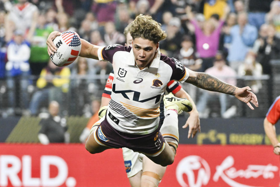 Broncos Reece Walsh is airborne as he scores a try during the NRL match between the Sydney Roosters and the Brisbane Broncos at Allegiant Stadium in Las Vegas, Saturday, March 2, 2024. (AP Photo/David Becker)