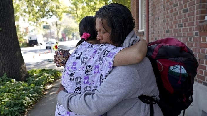 Eric Santos (right), who was recently evicted from his Sacramento apartment and now sleeps on an area park bench, gives a hug of thanks Tuesday to Karry Fowler, a volunteer at Showup Sac, a nonprofit that provides food, clothing and showers to people experiencing homelessness. (Photo: Rich Pedroncelli/AP)