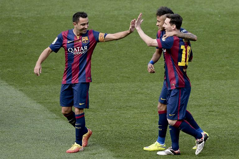 Barcelona's Lionel Messi (R) celebrates a goal with Neymar da Silva Santos (C) and Xavi Hernandez during the Spanish league match against RC Deportivo La Coruna at the Camp Nou stadium in Barcelona on May 23, 2015