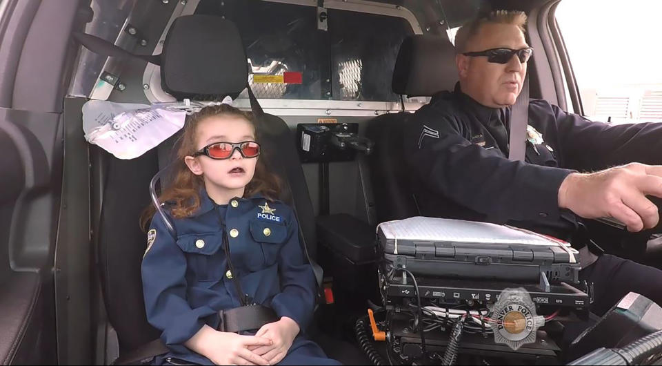 In this image made from April 2017 video provided by the Denver Police Department, Olivia Gant, who was 6 years old at the time, rides with Cpt. Tim Scudder on a call in Denver. On Monday, Oct. 21, 2019, a Douglas County, Colo., grand jury indicted the mother of Olivia Gant in connection with the little girl's 2017 death. Olivia's mother, Kelly Renee Turner, faces 13 charges, including first-degree murder. Olivia Gant was riding in the police car after Denver police made her an officer for a day. (Denver Police Department/The Denver Post via AP)