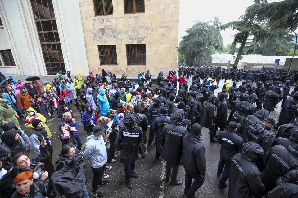 Demonstrators watch as police leave an area around the Parliament building during an opposition protest against "the Russian law" in the center of Tbilisi, Georgia, on Monday, May 13, 2024. Daily protests are continuing against a proposed bill that critics say would stifle media freedom and obstruct the country's bid to join the European Union. (AP Photo/Zurab Tsertsvadze)