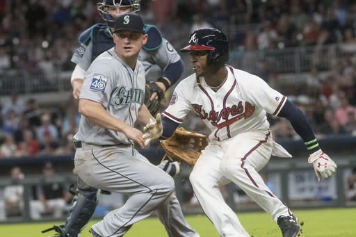 Atlanta Braves' Ozzie Albies, right, hits the brakes in a rundown as Seattle Mariners try to get him out. (AP)