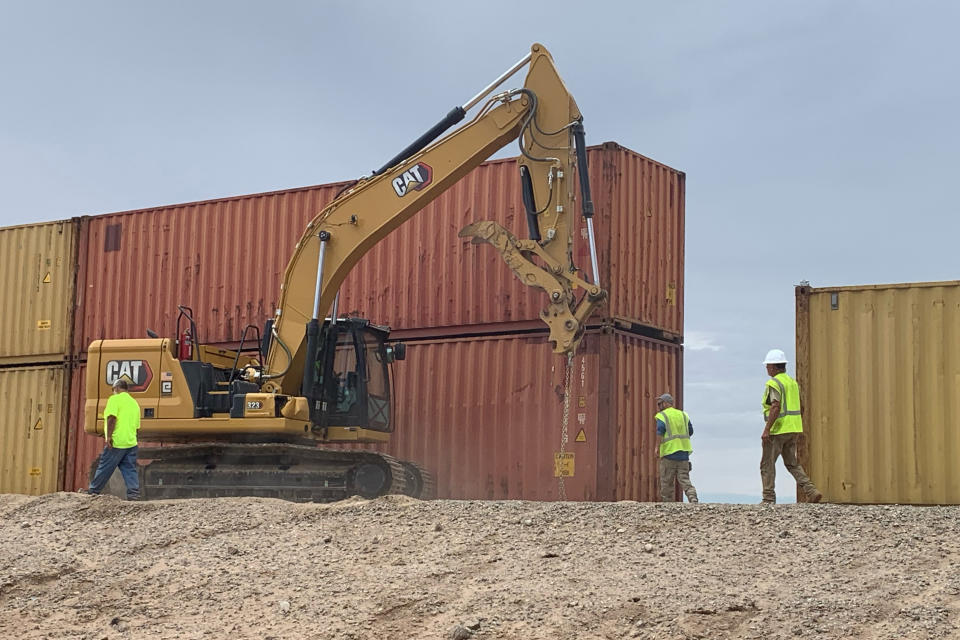 This photo provided by the Arizona Governor's Office shows shipping containers that will be used to fill a 1,000 foot gap in the border wall with Mexico near Yuma, Ariz., on Friday, Aug. 12, 2022. Two will be stacked atop each other and then topped with razor wire to slow migrants from crossing into Arizona. Republican Gov. Doug Ducey acted without federal permission and plans to fill three gaps totaling 3,000 feet in the coming weeks. (Arizona Governor's Office via AP)