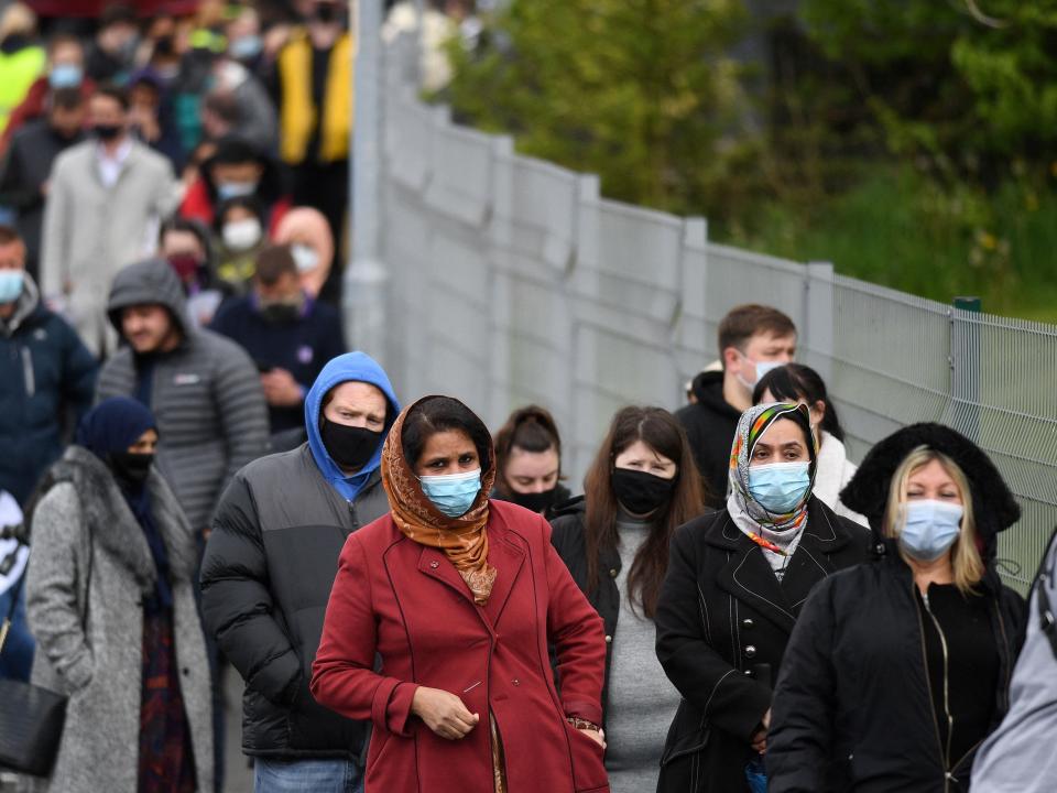 People queue to receive a Covid vaccine at a temporary vaccination centre at the Essa academy in Bolton, as the Indian variant rips through the northern Town (AFP via Getty Images)