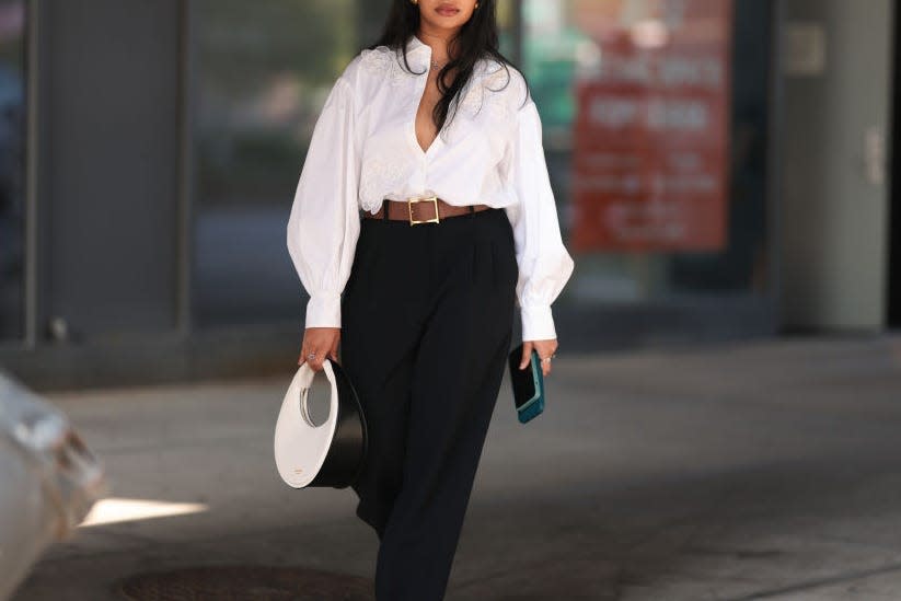 Woman with white blouse tucked into trousers