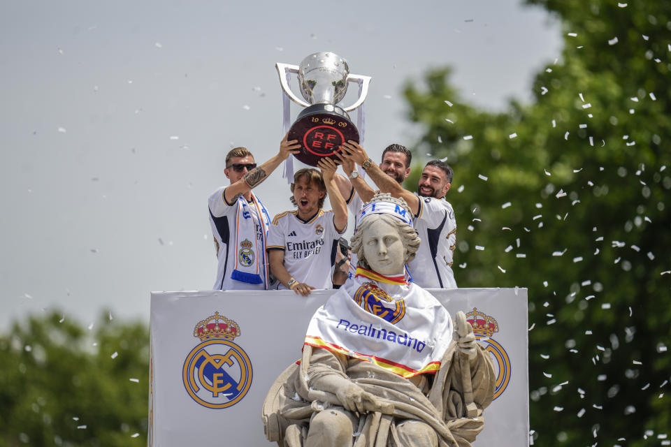 De izquierda a derecha, los jugadores del Real Madrid Toni Kroos, Luka Modric, Nacho y Dani Carvajal sostienen la copa de la Liga española durante la celebración del título en la plaza de Cibeles, en Madrid, el 12 de mayo de 2024. (AP Foto/Manu Fernández)