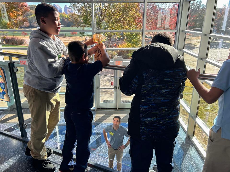 Justin Middaugh, an engineer from Michelin, watches as students at A.J. Whittenberg Elementary School of Engineering prepare to drop a paper bag with an egg inside off a railing at the school during engineering week.