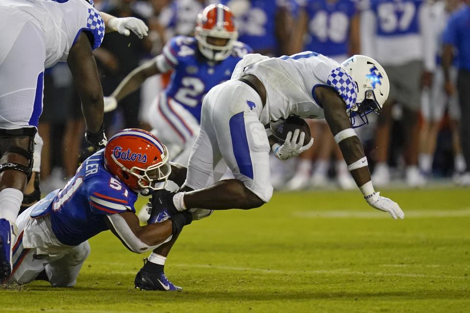 Kentucky running back Kavosiey Smoke, right, is tackled by Florida linebacker Ventrell Miller (51) during the first half of an NCAA college football game, Saturday, Sept. 10, 2022, in Gainesville, Fla. (AP Photo/John Raoux)