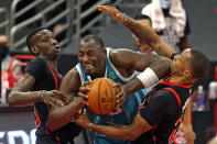 Charlotte Hornets center Bismack Biyombo (8) gets between Toronto Raptors forward Chris Boucher (25) and guard Norman Powell (24) during the second half of an NBA basketball game Saturday, Jan. 16, 2021, in Tampa, Fla. (AP Photo/Chris O'Meara)