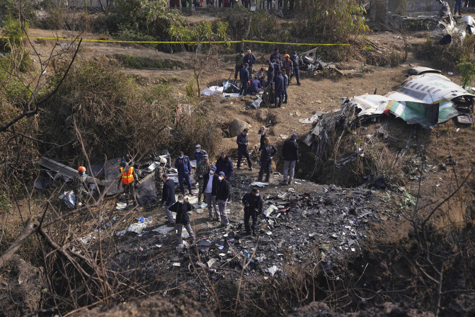 French investigators inspect the wreckage of a passenger plane at the crash site, in Pokhara, Nepal, Wednesday, Jan.18, 2023. Nepalese authorities are returning to families the bodies of plane crash victims and are sending the aircraft's data recorder to France for analysis as they try to determine what caused the country's deadliest air accident in 30 years. The flight plummeted into a gorge on Sunday while on approach to the newly opened Pokhara International Airport in the foothills of the Himalayas, killing all 72 aboard.(AP Photo/Yunish Gurung)