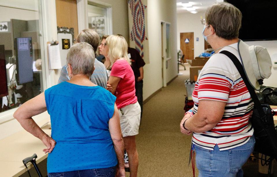 Vote-counting observers, including Cheryl McKinley, right, watch a monitor in the window and workers inside the tabulation room at the Shasta County Elections Office on Friday, June 10, 2022.