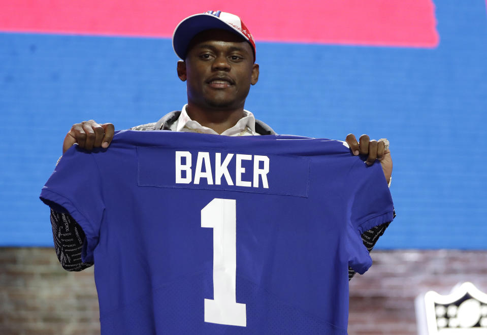 FILE - In this April 25, 2019, file photo, Georgia defensive back DeAndre Baker poses with his new jersey after the New York Giants selected him in the first round at the NFL football draft in Nashville, Tenn. Police in South Florida are trying to find Giants cornerback Baker and Seattle Seahawks cornerback Quinton Dunbar after multiple witnesses accused them of an armed robbery at a party. Miramar police issued arrest warrants for both men Thursday, May 14, 2020. (AP Photo/Mark Humphrey, File)