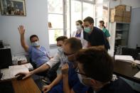 In this photo taken on Friday, May 8, 2020, ICU consultant Marios Karvouniaris, left, and internal medicine Agamemnon Bakakos, center, show medical students a CT of a patient at the COVID-19 Clinic of Sotiria Hospital in Athens. Greece's main hospital for the treatment of COVID-19 is also the focus of a hands-on training program for dozens of medical students who volunteered to relieve hard-pressed doctors from their simpler duties while gaining a close peek at the front lines of a struggle unmatched in modern medical history. (AP Photo/Thanassis Stavrakis)
