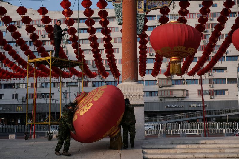 Workers dismantle decorations after the temple fair for the Chinese Lunar New Year in Ditan Park was canceled in Beijing