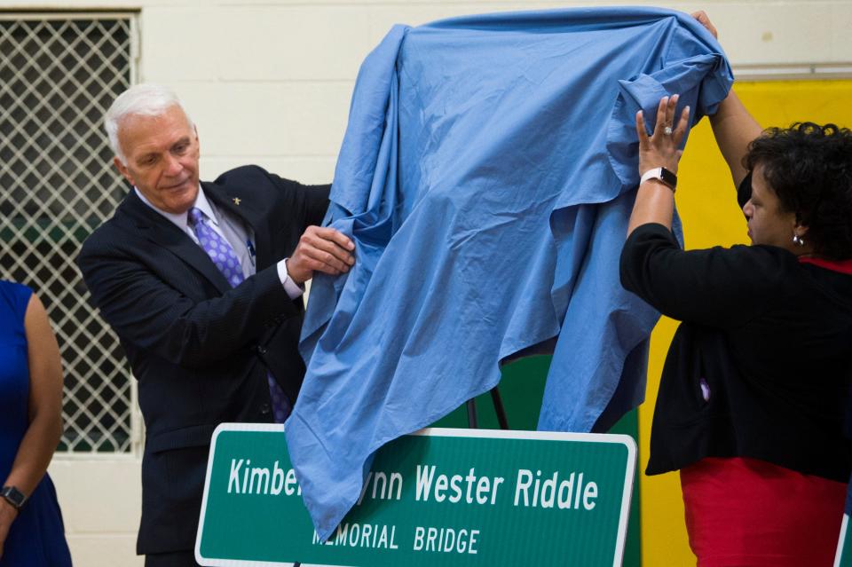 Knox County Schools Superintendant Bob Thomas helps unveil signs at a ceremony Thursday dedicating a bridge to the three victims of a 2014 school bus crash  at Milton Roberts Recreation Center.