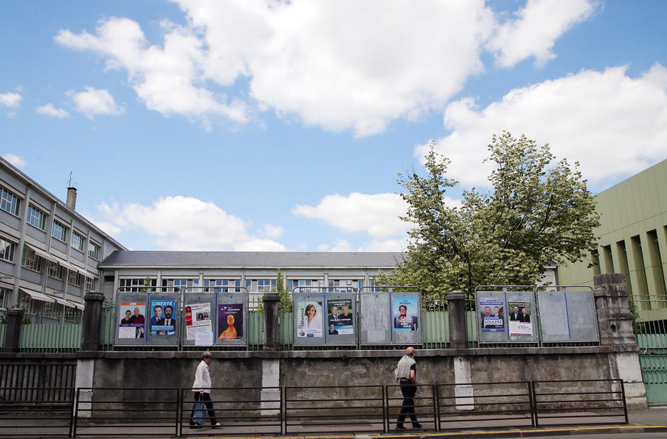 People walk past electoral posters of the upcoming parliamentary elections in Pau, southwestern France, Thursday, June 9, 2022. The legislative elections will take place on June 12 and 19, 2022. (AP Photo/Bob Edme)