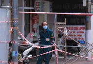 A security officer guards a road block in Vung Tau, Vietnam, Monday, Sept. 13, 2021. The roadblocks and barricades make the streets of this southern Vietnamese city look like they did during the war that ended almost 50 years ago. But this time, the battle is being fought against the rampaging coronavirus.(AP Photo/Hau Dinh)