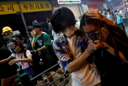 Anti-extradition bill protesters react after the police fired tear gas to disperse the demonstration at Sham Shui Po, in Hong Kong