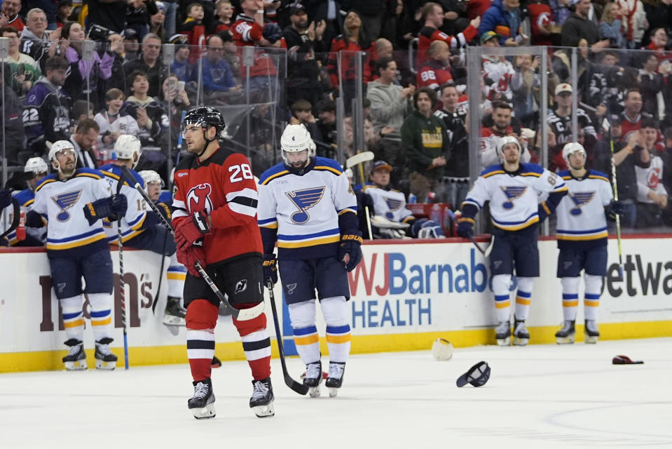 St. Louis Blues pause as fans toss hats on the ice after New Jersey Devils' Timo Meier (28) scored his third goal, during the second period of an NHL hockey game Thursday, March 7, 2024, in Newark, N.J. (AP Photo/Frank Franklin II)