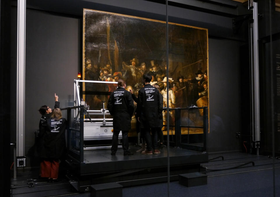 Technicians and researchers check equipment set up inside a glass chamber as they begin to study Rembrandt's 'Night Watch' masterpiece, at the Rijksmuseum in Amsterdam, Monday July 8, 2019. Researchers and restorers at Amsterdam's Rijksmuseum launched a months-long project Monday, using high-tech imaging technology to throw new light on Rembrandt van Rijn's iconic "Night Watch."(AP Photo/Aleksandar Furtula)