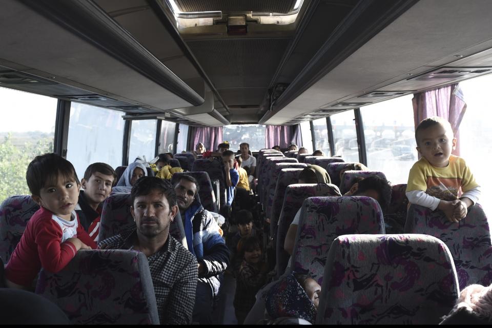 Refugees and migrants sit inside a bus at the toll stations of Malgara, near the Greek port city of Thessaloniki, on Wednesday, Oct. 23, 2019. Protesting local residents in northern Greece set up roadblocks to try and prevent migrants from settling in the area. The government has promised to expand a network of refugee camps and hotel residence programs on the Greek mainland in an effort to ease severe overcrowding at facilities on islands near the Turkish coast. (AP Photo/Giannis Papanikos)