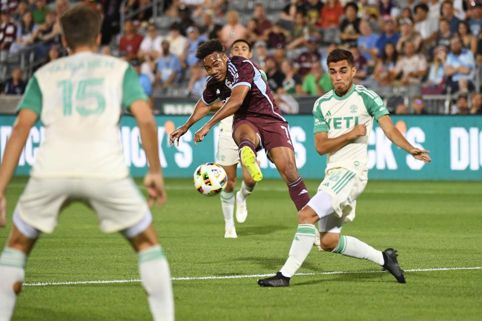 Colorado Rapids forward Jonathan Lewis, center, shoots the ball against Austin FC defender Hector Jimenez during the second half of Colorado's 2-0 win Saturday night at Dick's Sporting Goods Park. It was Austin FC's first match since June 1.