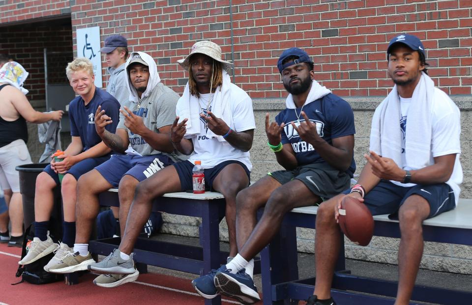 Members of the UNH football team await campers to arrive at the program's annual youth football camp this week at Wildcat Stadium.