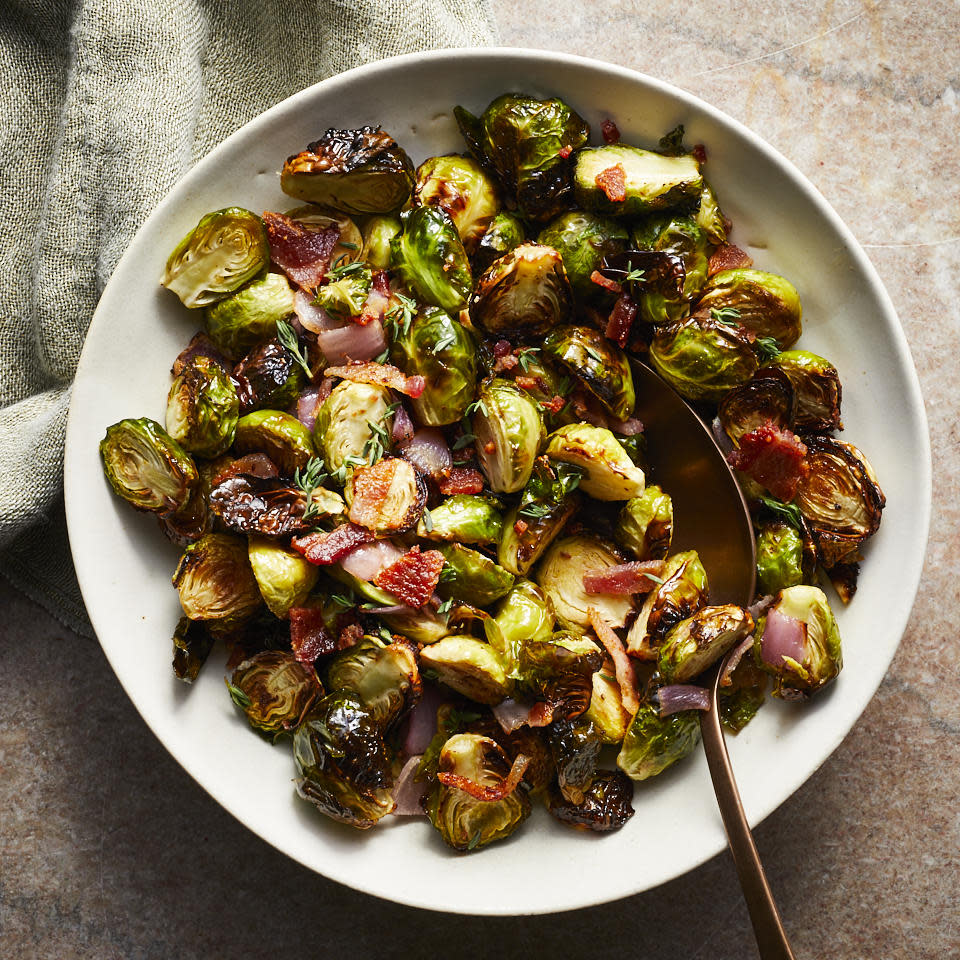 <p>These super-crispy and browned air-fryer Brussels sprouts with sweet onions and salty bacon--all amped up with bright lemon juice--are sure to be a hit, whether you serve them for a weeknight side dish or as part of your holiday spread for Thanksgiving. This recipe makes enough to serve eight but is easily halved, though once you taste it you may well want a double serving. And if you prefer a vegetarian side, simply omit the bacon. <a href="https://www.eatingwell.com/recipe/277262/air-fryer-brussels-sprouts/" rel="nofollow noopener" target="_blank" data-ylk="slk:View Recipe;elm:context_link;itc:0;sec:content-canvas" class="link ">View Recipe</a></p>