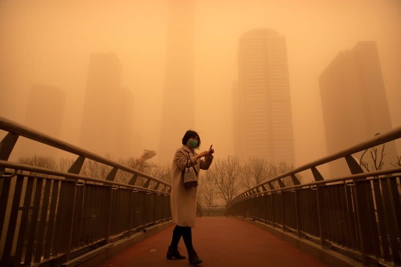 ▲中國北方遭逢近10年最強沙塵暴，北京市15日一早便是昏黃一片。（圖／美聯社／達志影像）